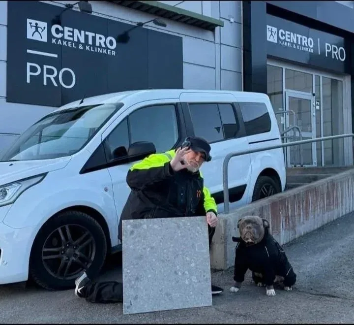 Variatis ägare med sin hund framför Centro Kakel & Klinker